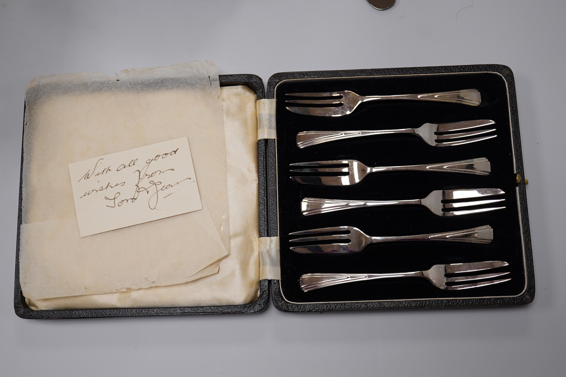 A George V silver Corinthian column candlestick, Birmingham, 1913, 16.1cm, a cased set of silver silver coffee spoons, two cased plated sets and a silver handled steel butter knife.